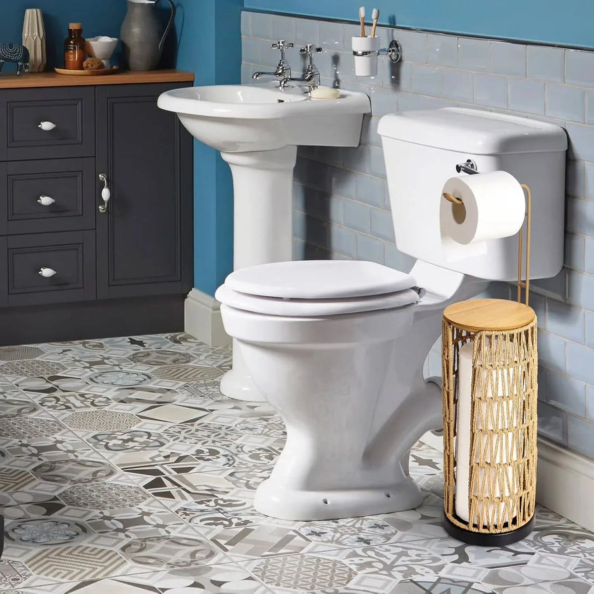 Handmade woven toilet paper holder by eprolo in a bathroom with blue walls and patterned tiles.
