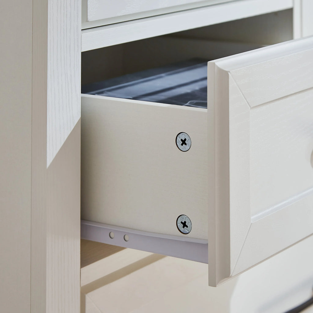 Close-up of an open white wooden drawer from an eprolo farmhouse 5 drawer dressing table.