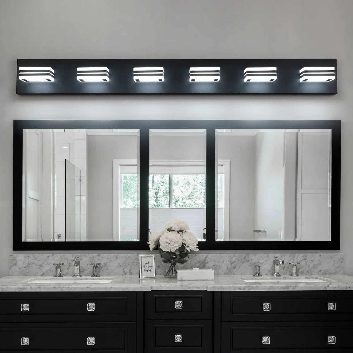 Modern eprolo black LED vanity lights installed over a large bathroom mirror and marble vanity.