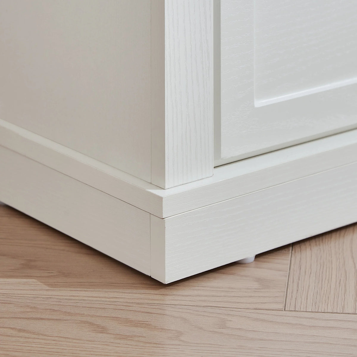 Close-up of the white wooden base and molding of an eprolo farmhouse dressing table.