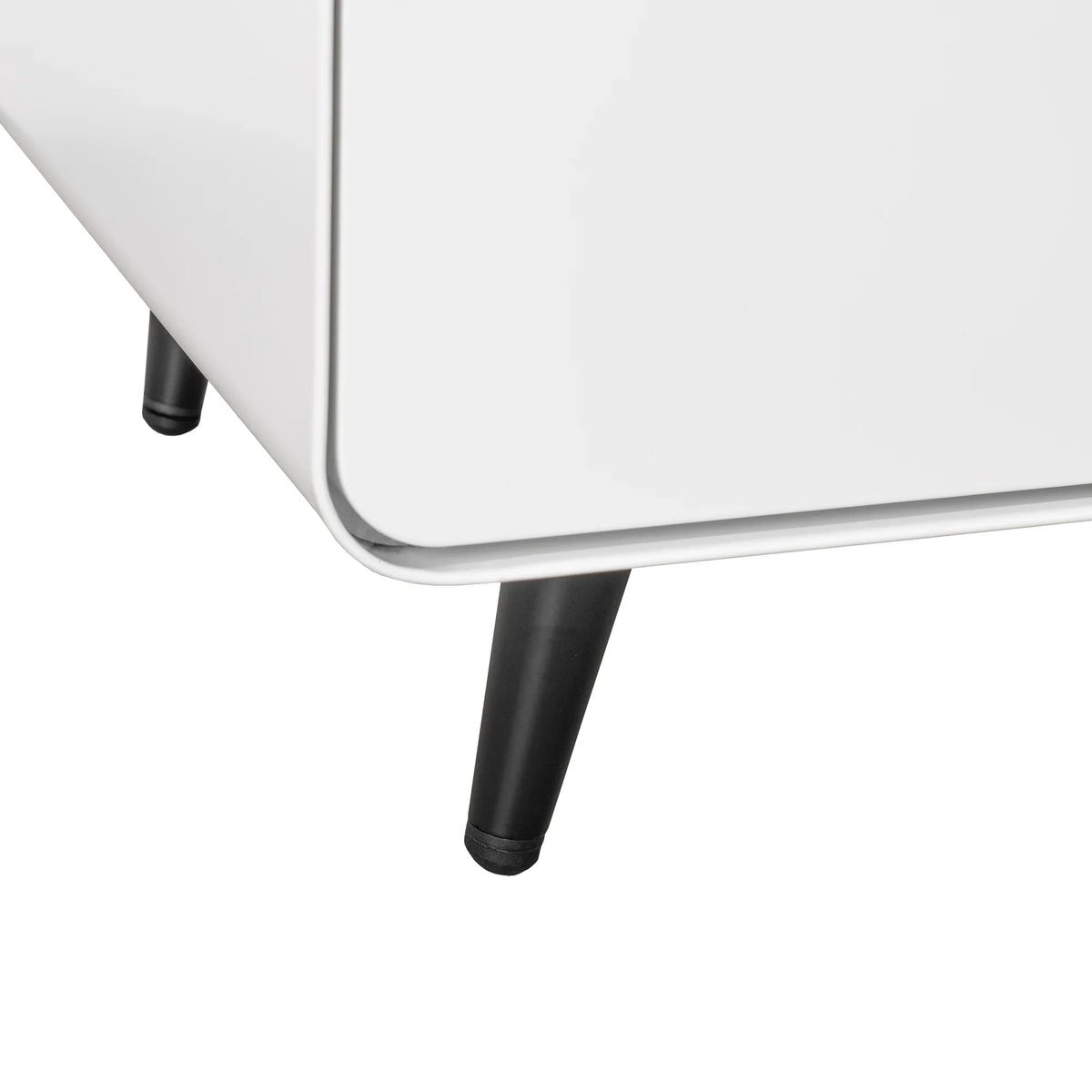 Close-up of black tapered metal legs on an eprolo white modern night stand storage cabinet.