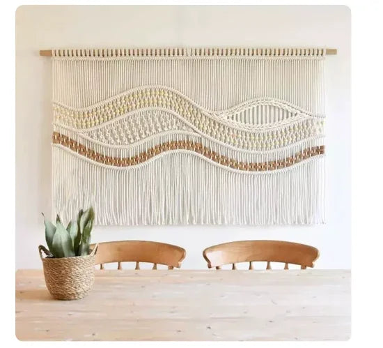 Boho macrame wall hanging tapestry with wavy patterns hanging above a wooden dining table.
