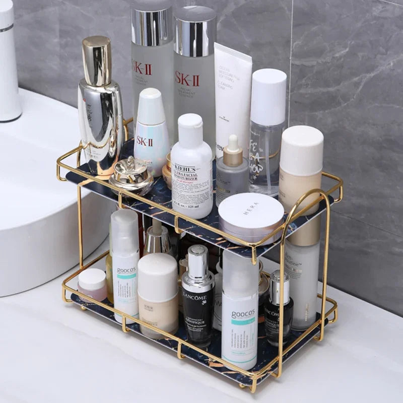 Double-layer golden iron cosmetic storage rack with various skincare bottles on a bathroom counter.