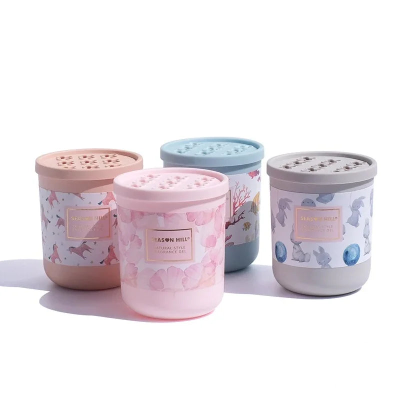 Four Season Hill fragrance gel containers in pink, blue, and grey with decorative patterns.