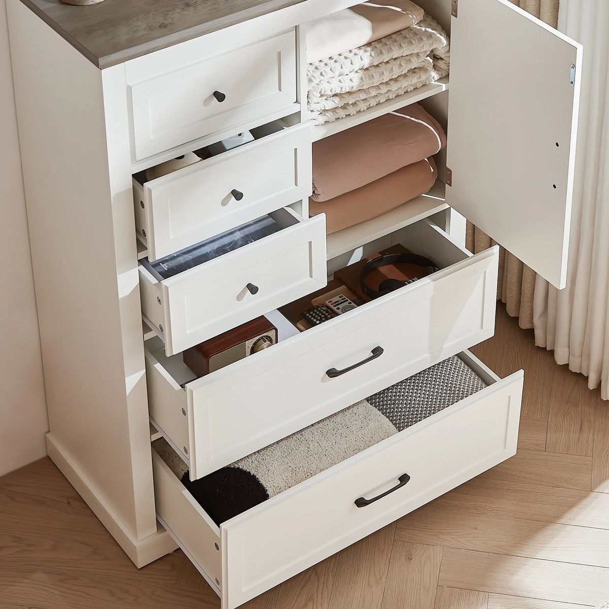 White farmhouse 5 drawer bedroom dressing table with open drawers containing linens.