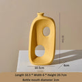 Modern yellow eprolo ceramic vase with abstract cut-outs and dimensions.