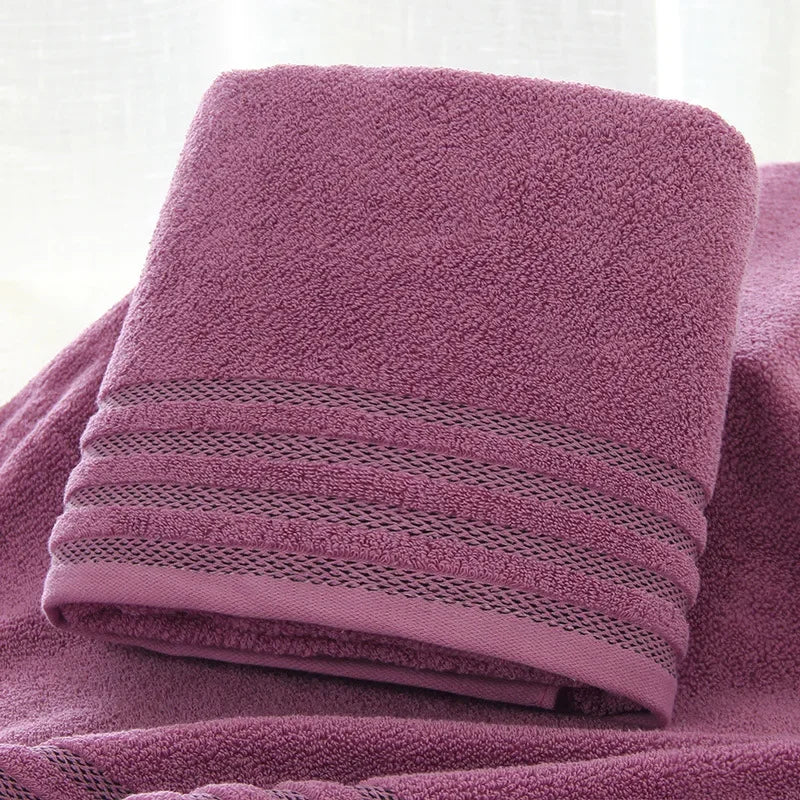 Folded purple eprolo thick cotton bath towel with decorative stripe texture