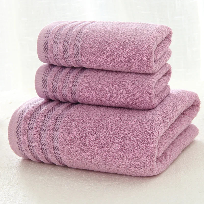 Set of three thick, solid purple eprolo cotton bath towels with decorative stripes.