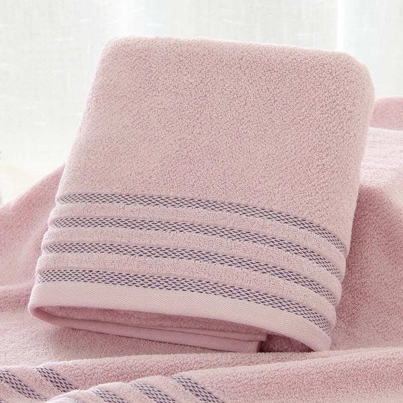 Folded pink eprolo cotton bath towel with decorative stripes