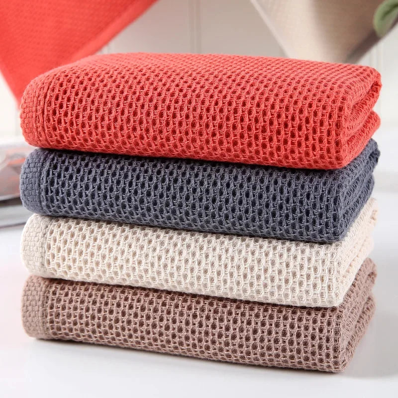 A stack of four eprolo cotton waffle weave hand towels in red, grey, cream, and brown.
